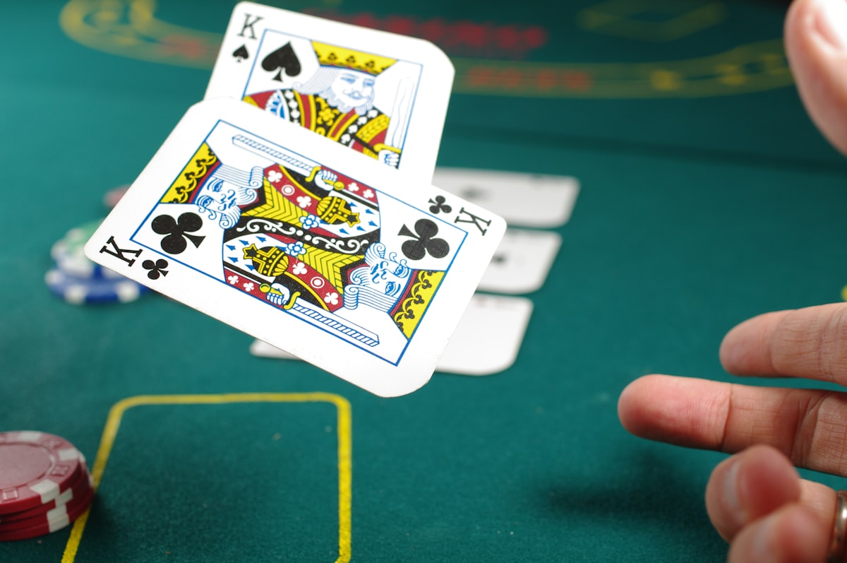 Meja blackjack dengan dealer dan pemain di kasino — ilustrasi artikel editorial Bintaro88