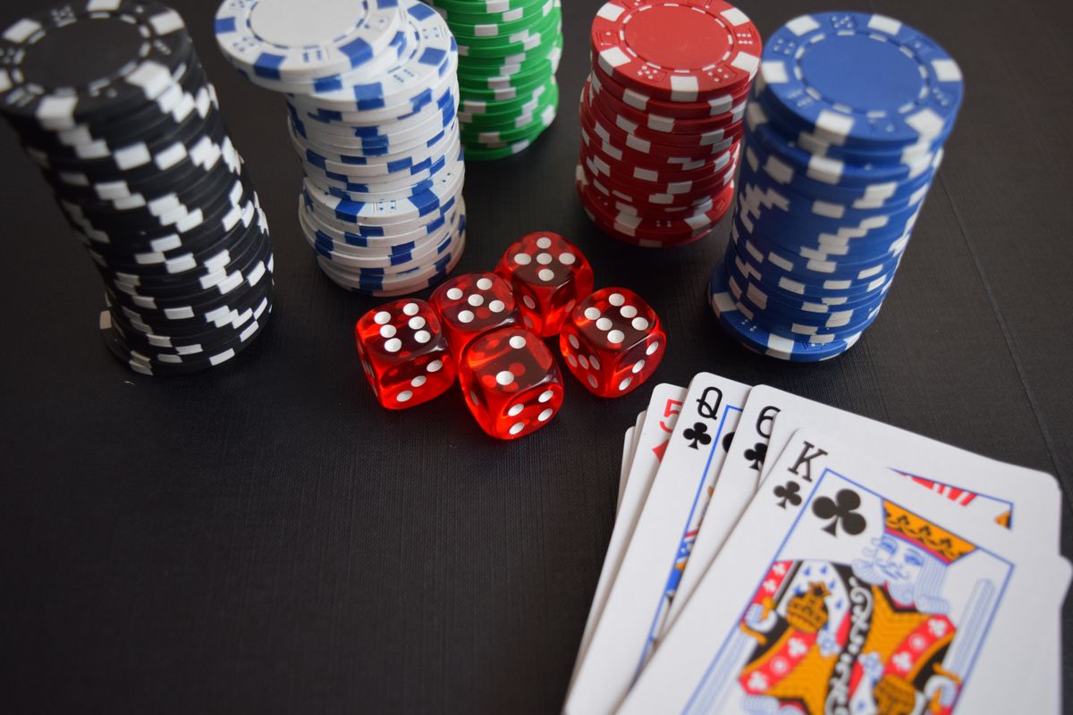 Susunan chip, kartu remi, dan dadu di atas meja